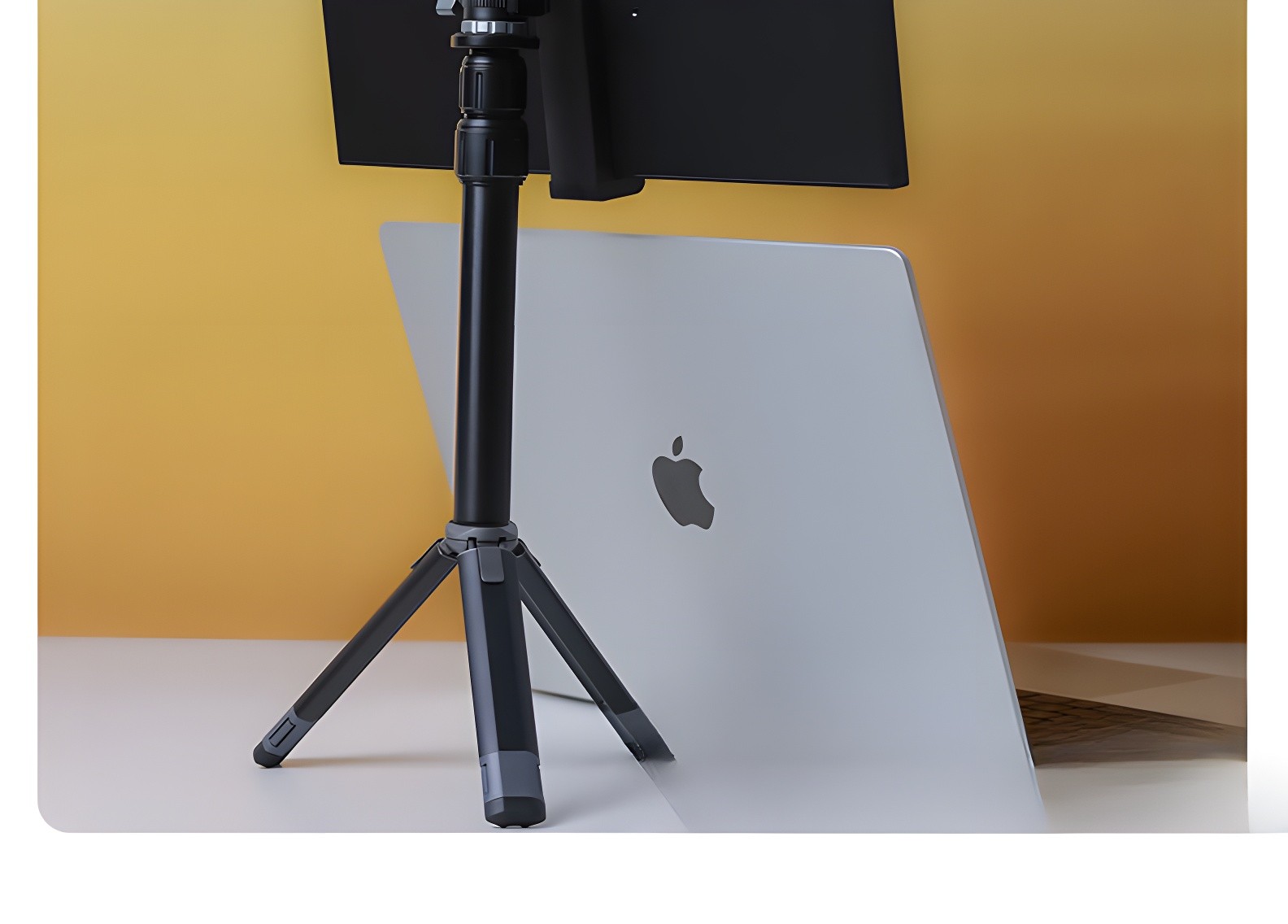 Black portable monitor stand supporting a laptop with Apple logo
