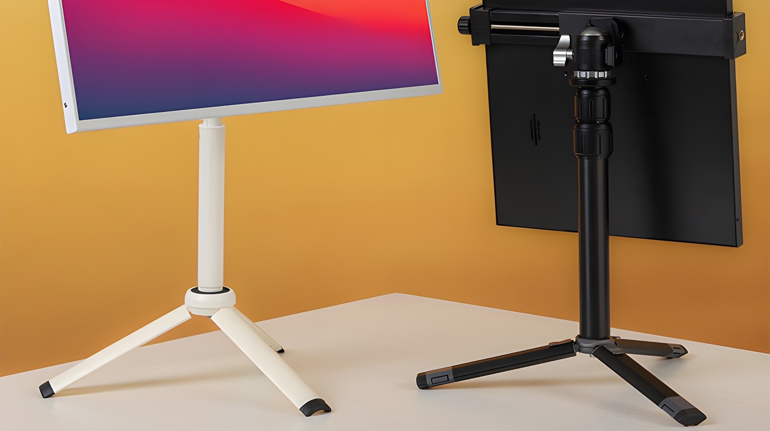 White and black portable monitor stands side by side on a desk