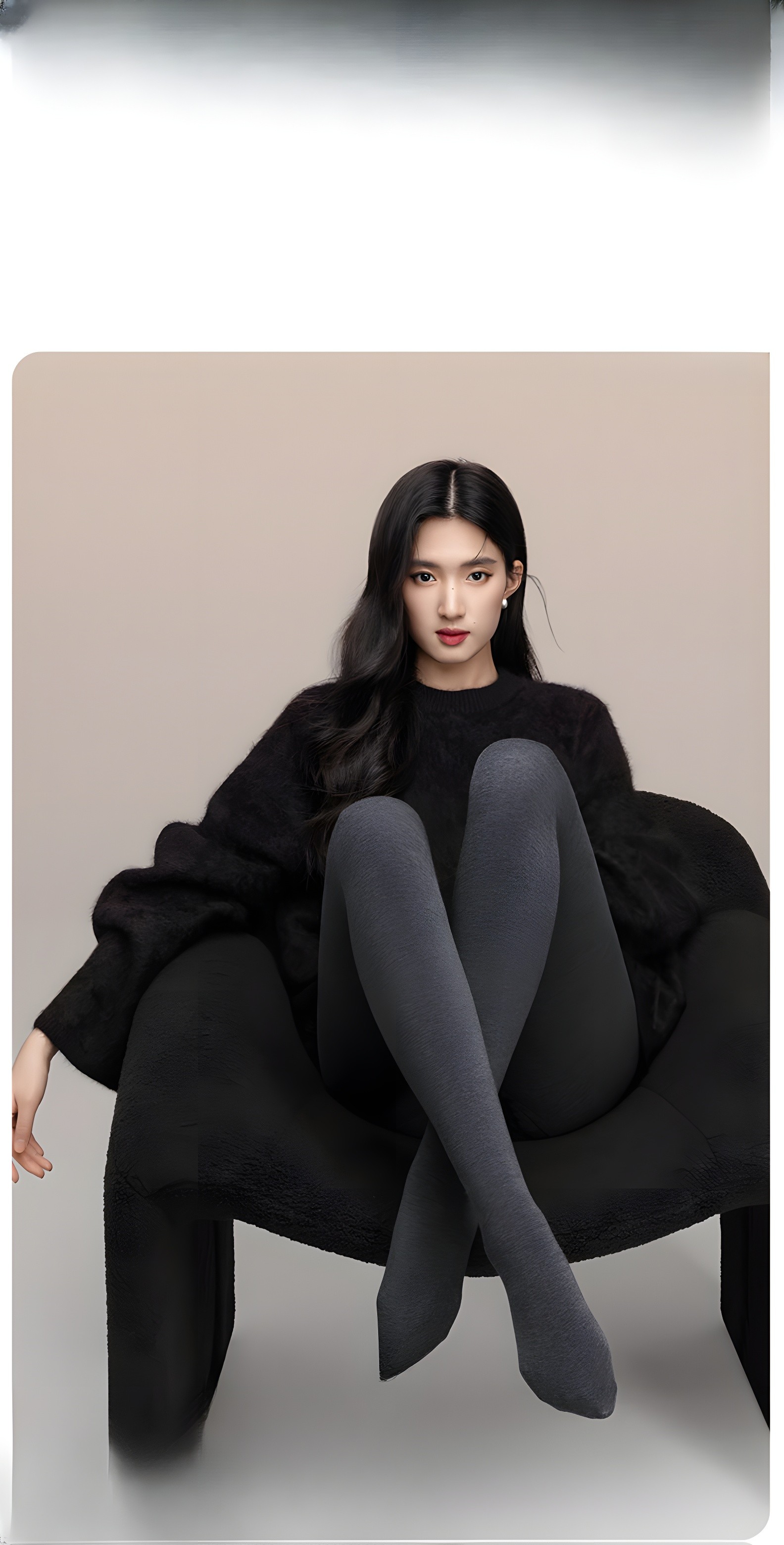 Model sitting elegantly in black thermal tights and oversized sweater