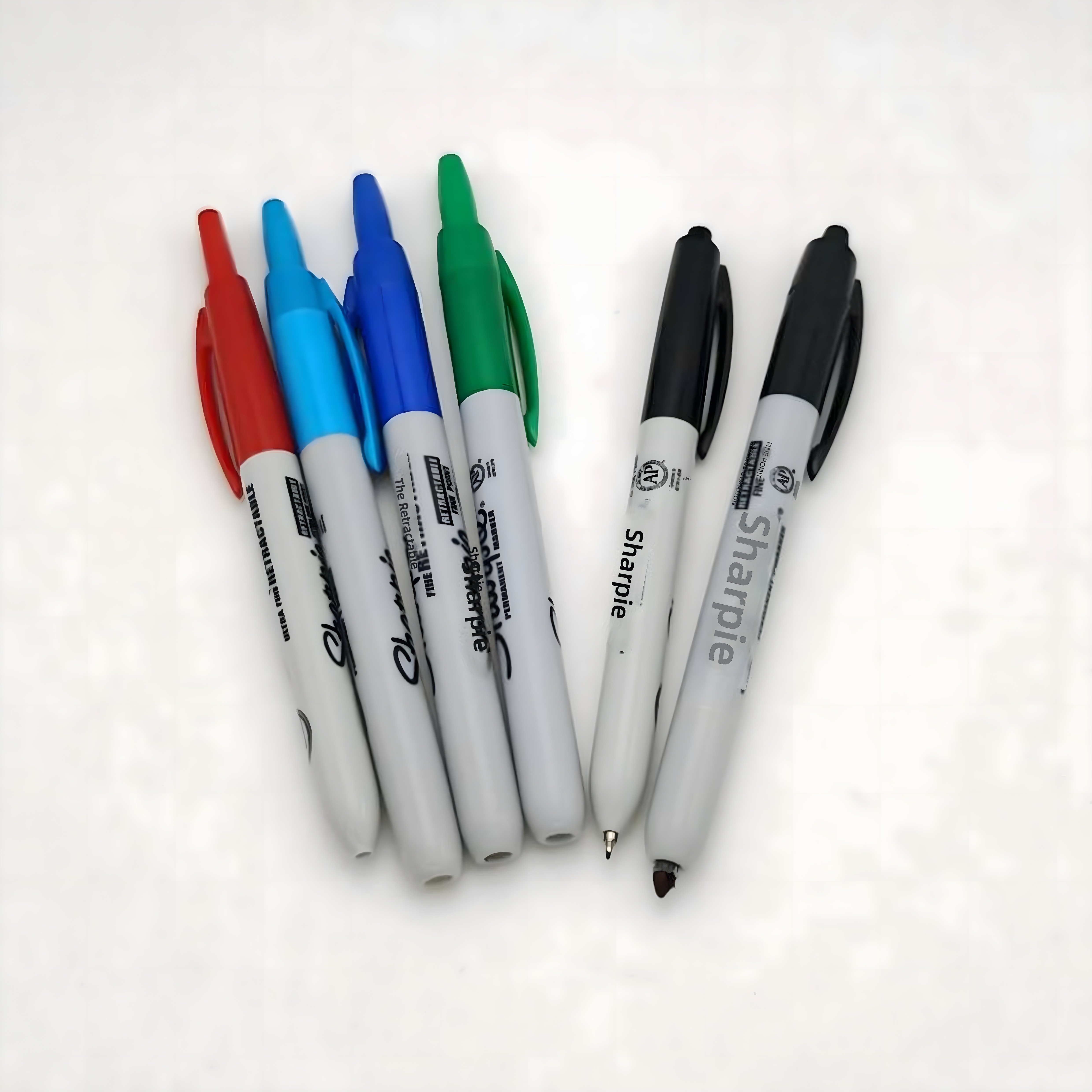 Group of six Sharpie markers, including fine and ultra-fine points, arranged neatly